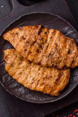 Lezzetli taze ızgara tavuk filetosu, esrarlı baharatlar ve çimento kaplı otlar. Ateşte pişirilmiş bir tabak.