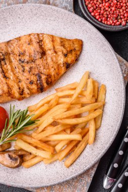 Lezzetli taze ızgara tavuk filetosu, esrarlı baharatlar ve çimento kaplı otlar. Ateşte pişirilmiş bir tabak.