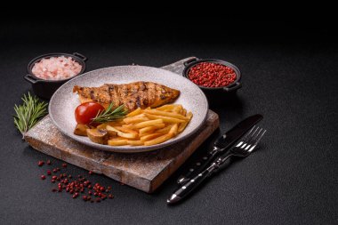 Lezzetli taze ızgara tavuk filetosu, esrarlı baharatlar ve çimento kaplı otlar. Ateşte pişirilmiş bir tabak.