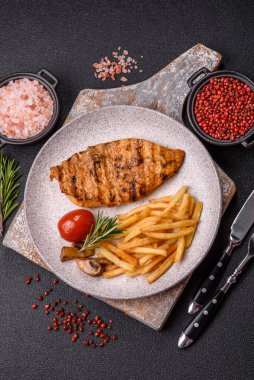 Lezzetli taze ızgara tavuk filetosu, esrarlı baharatlar ve çimento kaplı otlar. Ateşte pişirilmiş bir tabak.