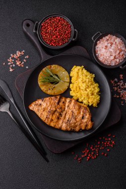 Lezzetli taze ızgara tavuk filetosu, esrarlı baharatlar ve çimento kaplı otlar. Ateşte pişirilmiş bir tabak.