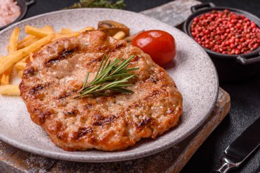 Lezzetli taze ızgara hindi filetosu, koyu beton arka planda baharatlar ve otlar. Ateşte pişirilmiş bir tabak.