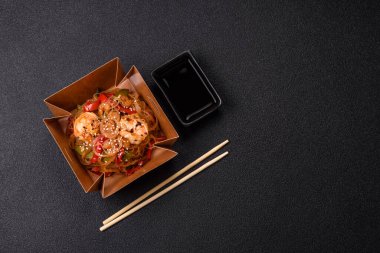 Karides, deniz mahsulü, sebze, baharat ve soya soslu, koyu beton kaplama erişte.