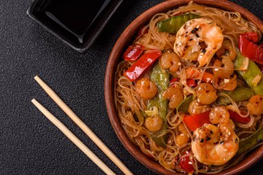 Karides, deniz mahsulü, sebze, baharat ve soya soslu, koyu beton kaplama erişte.