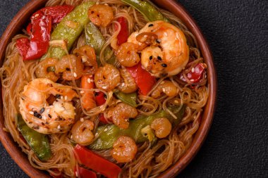 Karides, deniz mahsulü, sebze, baharat ve soya soslu, koyu beton kaplama erişte.