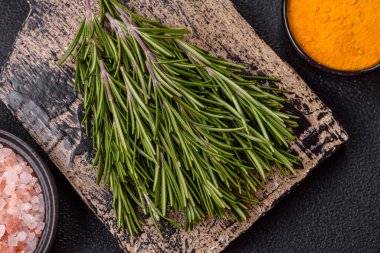 Taze yeşil biberiye filizleri pişirmeye hazır, koyu beton arka planda.