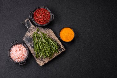 Taze yeşil biberiye filizleri pişirmeye hazır, koyu beton arka planda.