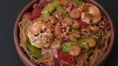 Karides, deniz mahsulü, sebze, baharat ve soya soslu, koyu beton kaplama erişte.