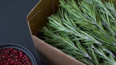 Taze yeşil biberiye filizleri pişirmeye hazır, koyu beton arka planda.