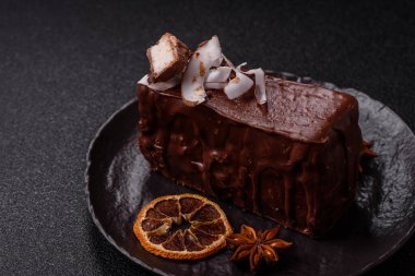 Hindistan cevizi gevrekleri ve koyu beton arka planda sünger keki ile çikolatalı tatlı pasta.