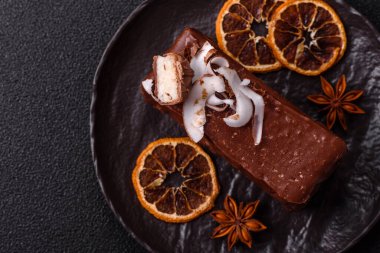 Hindistan cevizi gevrekleri ve koyu beton arka planda sünger keki ile çikolatalı tatlı pasta.