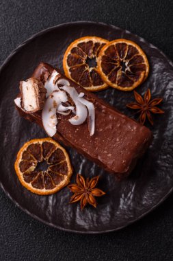 Hindistan cevizi gevrekleri ve koyu beton arka planda sünger keki ile çikolatalı tatlı pasta.