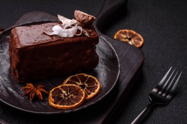 Hindistan cevizi gevrekleri ve koyu beton arka planda sünger keki ile çikolatalı tatlı pasta.