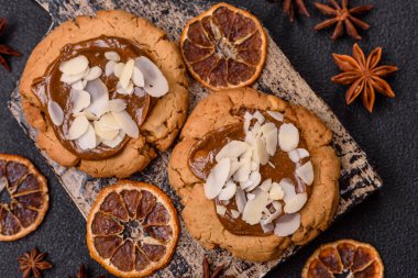 Koyu beton arka planda fındıklı ve çikolatalı kurabiyeler.