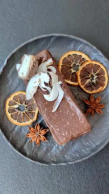 Hindistan cevizi gevrekleri ve koyu beton arka planda sünger keki ile çikolatalı tatlı pasta.