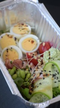 Kaynamış yumurta, jambon, domates, yeşil fasulye, koyu beton arkaplanda aioli sosu içeren sağlıklı bir kahvaltı.