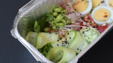 Kaynamış yumurta, jambon, domates, yeşil fasulye, koyu beton arkaplanda aioli sosu içeren sağlıklı bir kahvaltı.