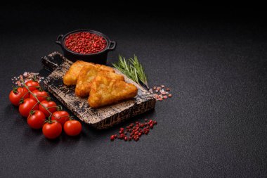 Koyu beton arka planda patates, soğan, tuz ve baharatlı mücver.