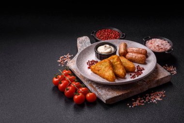 Koyu beton arka planda patates, soğan, tuz ve baharatlı mücver.