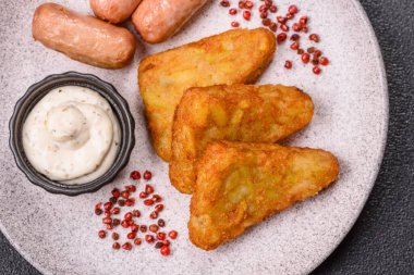 Koyu beton arka planda patates, soğan, tuz ve baharatlı mücver.