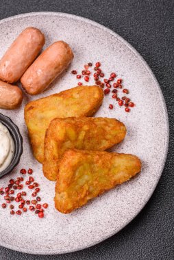 Koyu beton arka planda patates, soğan, tuz ve baharatlı mücver.