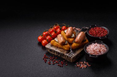 Koyu beton arka planda patates, soğan, tuz ve baharatlı mücver.