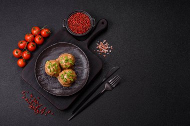 Koyu beton arkaplanda kremalı karamel soslu tuz ve baharatlı köfteler.