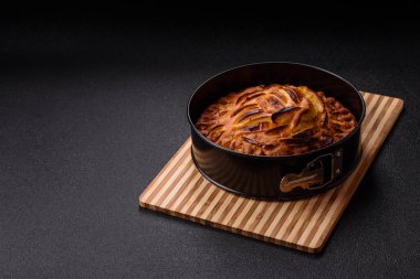 Koyu beton bir arka planda fırında elmalı turta.