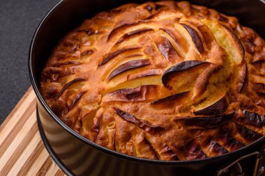 Koyu beton bir arka planda fırında elmalı turta.