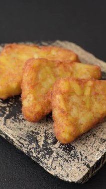 Koyu beton arka planda patates, soğan, tuz ve baharatlı mücver.