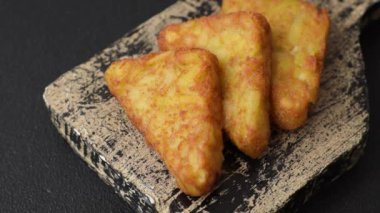 Koyu beton arka planda patates, soğan, tuz ve baharatlı mücver.