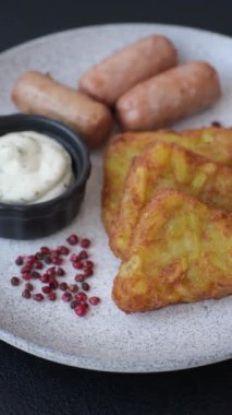 Koyu beton arka planda patates, soğan, tuz ve baharatlı mücver.