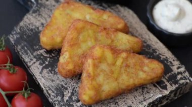 Koyu beton arka planda patates, soğan, tuz ve baharatlı mücver.