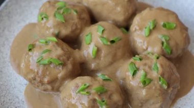 Koyu beton arkaplanda kremalı karamel soslu tuz ve baharatlı köfteler.