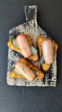 Koyu beton arka planda patates, soğan, tuz ve baharatlı mücver.