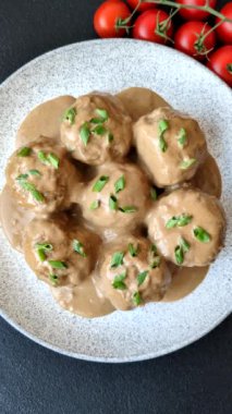 Koyu beton arkaplanda kremalı karamel soslu tuz ve baharatlı köfteler.