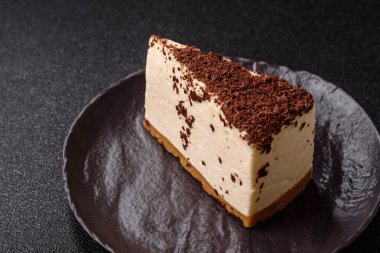 Üzerine çikolata kırıntıları serpiştirilmiş mascarpone peyniri serpiştirilmiş lezzetli bir cheesecake.
