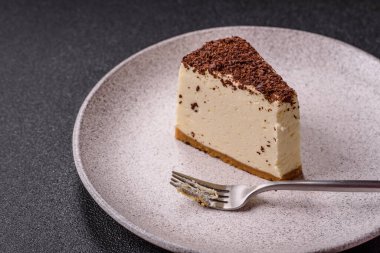 Üzerine çikolata kırıntıları serpiştirilmiş mascarpone peyniri serpiştirilmiş lezzetli bir cheesecake.