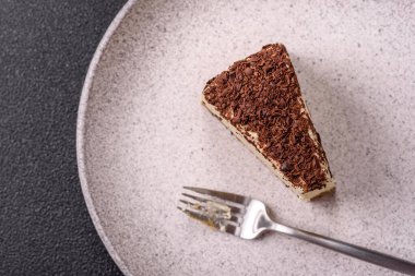 Üzerine çikolata kırıntıları serpiştirilmiş mascarpone peyniri serpiştirilmiş lezzetli bir cheesecake.