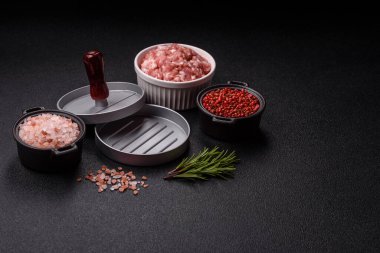 Koyu beton zeminde hamburgerler için kıyma yapmak için metal pres.