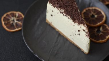 Üzerine çikolata kırıntıları serpiştirilmiş mascarpone peyniri serpiştirilmiş lezzetli bir cheesecake.