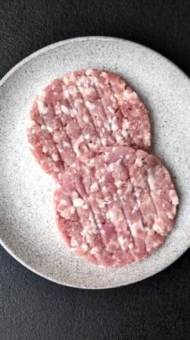 Taze çiğ et ya da tuzlu ve baharatlı domuz burger köftesi.