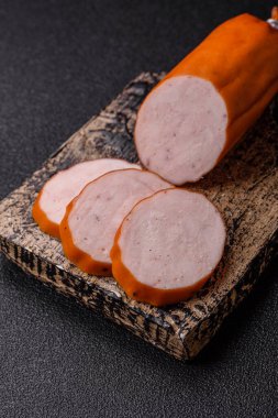 Lezzetli taze jambon, tuz, baharat ve otlarla kesilmiş koyu beton arka planda yuvarlak dilimler halinde.