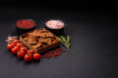 Tohumlar, tanecikler, tuz, baharatlar ve çimento kaplı ev yapımı çıtır kahverengi ekmek cipsleri.