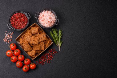 Tohumlar, tanecikler, tuz, baharatlar ve çimento kaplı ev yapımı çıtır kahverengi ekmek cipsleri.