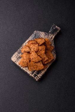 Tohumlar, tanecikler, tuz, baharatlar ve çimento kaplı ev yapımı çıtır kahverengi ekmek cipsleri.