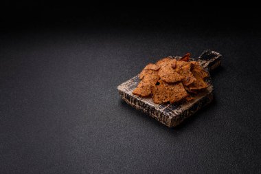 Tohumlar, tanecikler, tuz, baharatlar ve çimento kaplı ev yapımı çıtır kahverengi ekmek cipsleri.