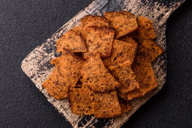 Tohumlar, tanecikler, tuz, baharatlar ve çimento kaplı ev yapımı çıtır kahverengi ekmek cipsleri.