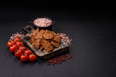 Tohumlar, tanecikler, tuz, baharatlar ve çimento kaplı ev yapımı çıtır kahverengi ekmek cipsleri.