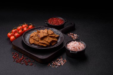 Tohumlar, tanecikler, tuz, baharatlar ve çimento kaplı ev yapımı çıtır kahverengi ekmek cipsleri.